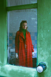 Young woman standing against wall