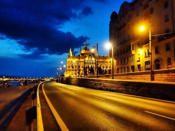 Illuminated road against sky in city at night