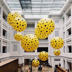 Yellow spotted decoration hanging over people at building