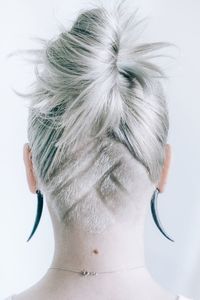 Rear view of woman with hairstyle against wall