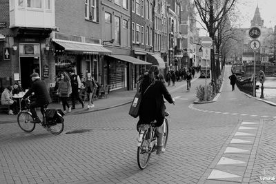 People walking on street amidst buildings in city