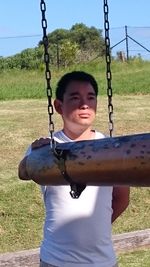 Portrait of boy on swing at playground