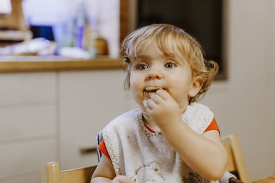 Close-up of cute girl eating at home
