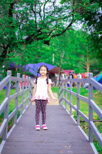 Portrait of woman standing on footbridge