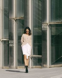 Full length of woman walking against building