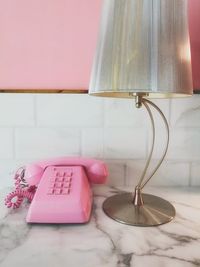 Close-up of electric lamp on wall at home