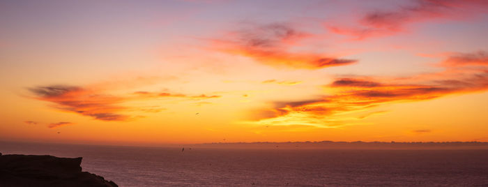 Scenic view of sea against romantic sky at sunset