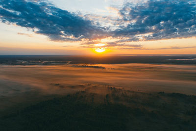 Field covered by fog at sunrise, top view