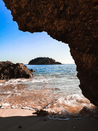 Rock formation on beach against sky