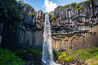 Low angle view of waterfall against sky