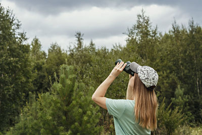 Rear view of woman photographing against sky