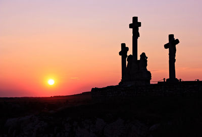 Silhouette statue against sky during sunset