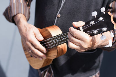 Midsection of man playing guitar