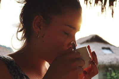 Close-up portrait of young woman smoking cigarette