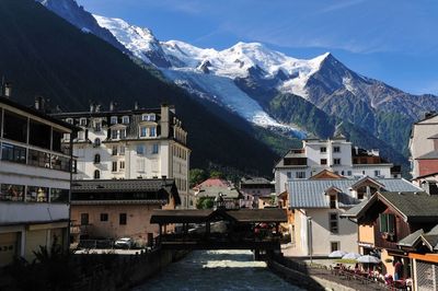 Buildings in town against mountains during winter