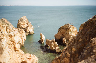 Rocks on sea shore against sky