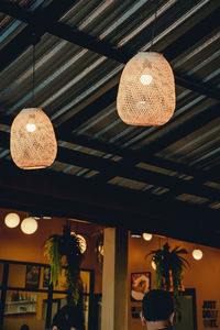 Low angle view of illuminated pendant lights hanging from ceiling at restaurant