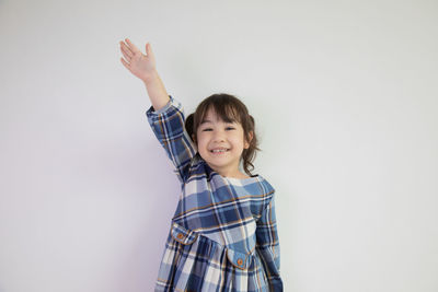 Portrait of happy boy standing against white background