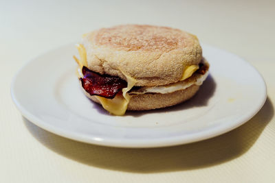 Close-up of english muffin with bacon and egg served in plate