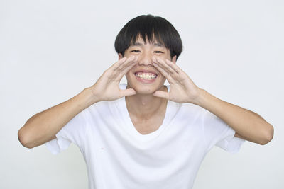 Portrait of smiling man standing against white background