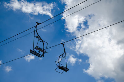 Ski lift chairs with no one on them - against cloudy sky