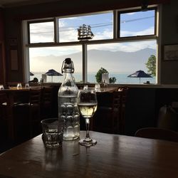 Beer glass on table by window