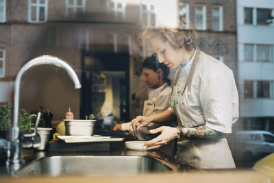 Side view of a man preparing food in kitchen