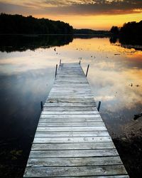 Wooden jetty on pier at lake during sunset