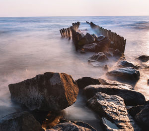 Scenic view of rocks in sea against sky