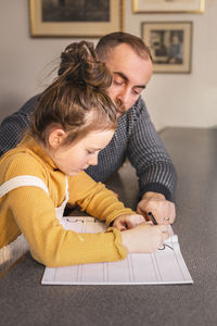 Father helping daughter with homework