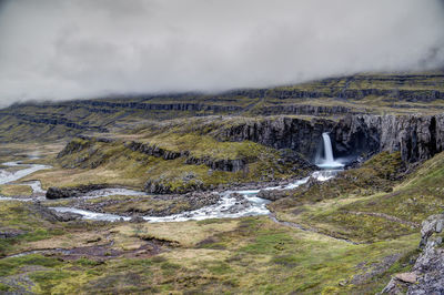 Scenic view of waterfall against sky