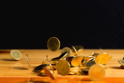 Close-up of coins on table against black background