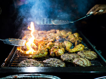 Close-up of meat on barbecue grill with fire. 