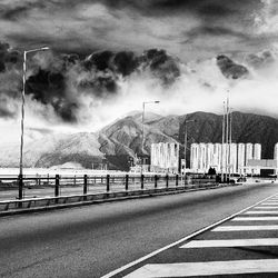 Empty road against cloudy sky