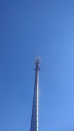 Low angle view of communications tower against clear blue sky