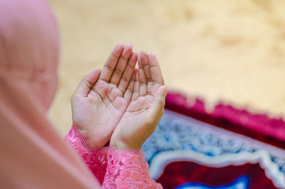 Cropped image of woman praying with hands cupped