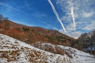 Scenic view of snow covered mountain against blue sky