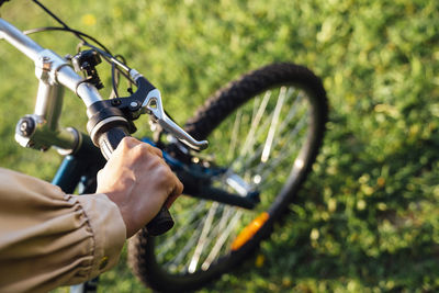 Hands of woman on handlebar in park