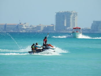 People riding jet ski at sea