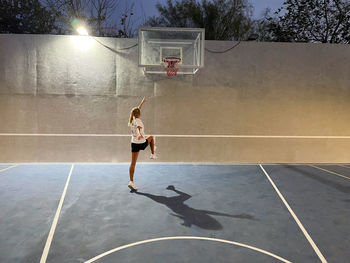 Woman at the basketball courts at night in action