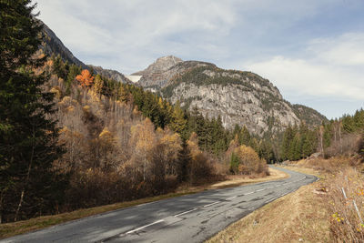 Road amidst trees against sky