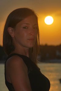 Close-up portrait of beautiful young woman during sunset