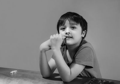 Portrait of smiling boy sitting on table