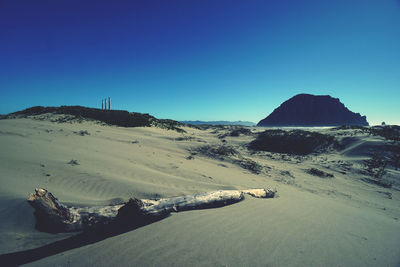 Scenic view of desert against clear blue sky