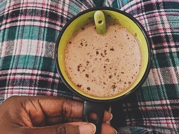 Directly above shot of hand holding coffee cup