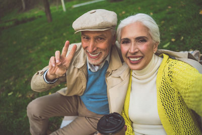 Portrait smiling couple doing selfie while sitting at park