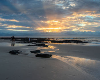 Scenic view of beach against sky during sunset