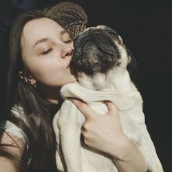 Close-up of young woman holding dog