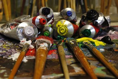 Close-up of colorful paint tubes and brushes on palette