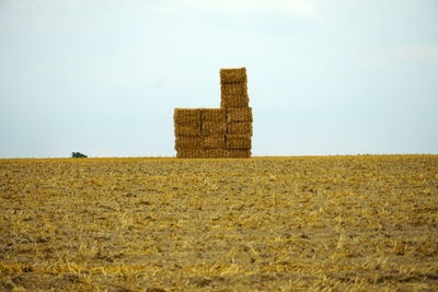 Hay bales on field against clear sky